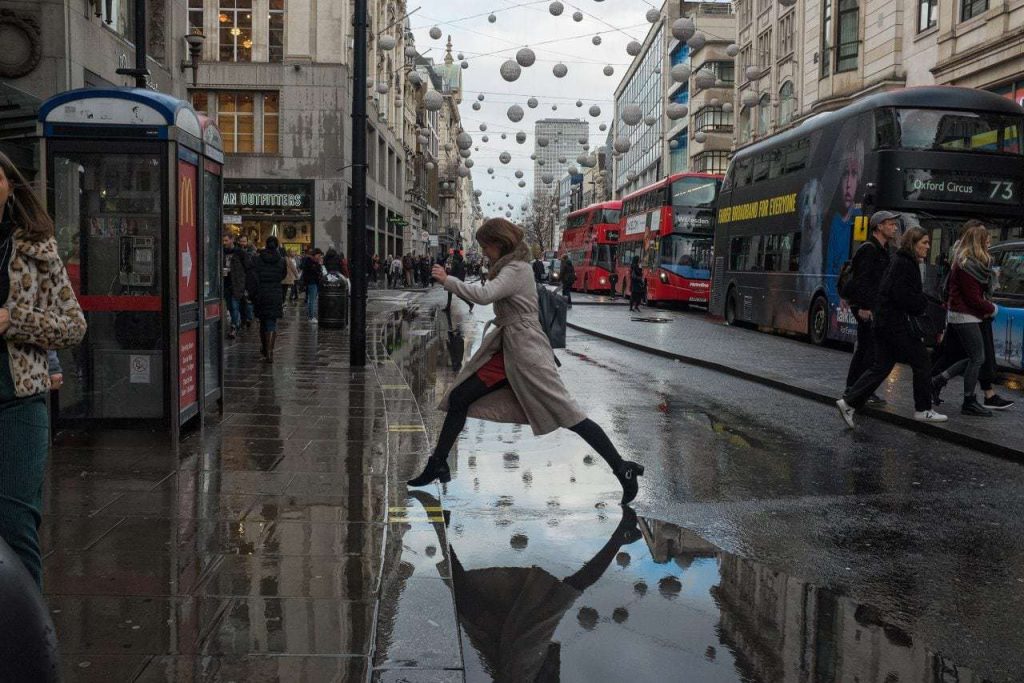 تصویری از یک زن در خیابان بارانی